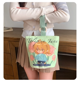 Detail of light green canvas tote bag with wooden handle and tulip illustration on wrist