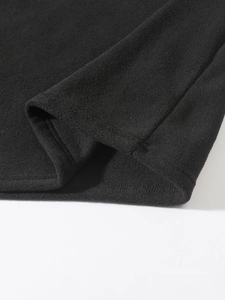 Close-up of black fleece jacket cuff showing premium stitching and fabric texture