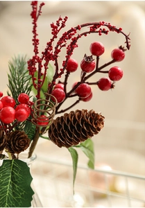 Close-up of red berries and pine cones on a decorative branch for Christmas festive decor
