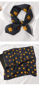 Vues détaillées d'un foulard en soie gris foncé avec motifs trèfle jaune sur fond en soie