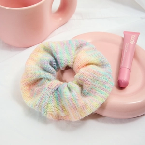 Elastico per capelli in maglia sfumata macaron su un vassoio di ceramica rosa