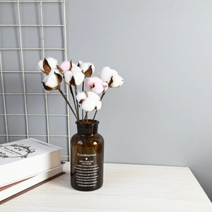 Natural dried cotton flower branches in a brown glass vase for Nordic home decor