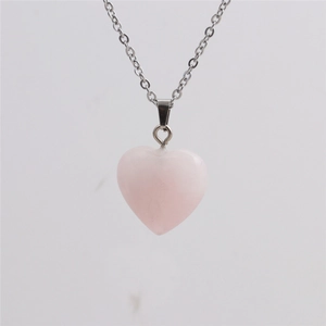 Close-up of heart-shaped rose quartz pendant on a delicate silver chain necklace