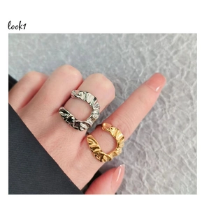 Detail shot of the irregular fold texture on gold and silver minimalist open U-shaped rings