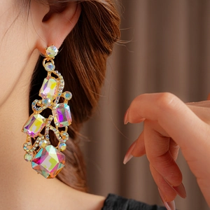 Macro detail of vintage gold square earrings featuring iridescent rectangle crystals