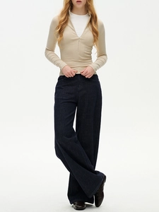Detail of slim-fit thermal mock neck top with zipper in beige paired with blue jeans