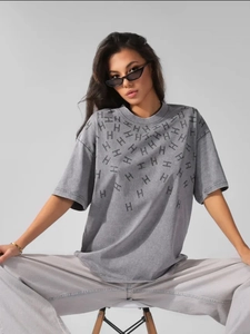 Close-up of acid-washed cotton fabric texture and H-letter pattern on grey vintage tee