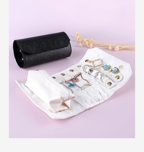Macro view of portable jewelry organizer roll with rings and earrings compartments