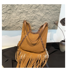 Detail of bohemian suede tote with fringe, studs and embossed sun pattern design