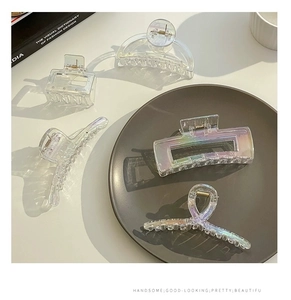 Close-up of holographic clear geometric shark clips including rectangular and arched styles