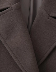 Macro detail of high-quality dark coffee wool fabric texture and notched lapel collar