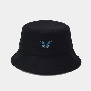 Close-up of fine blue butterfly embroidery detail on a black cotton bucket hat fabric