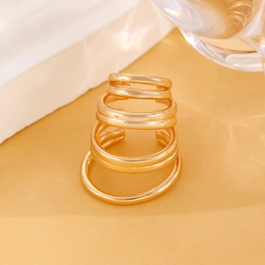 Minimalist multi-layer gold metal ear cuff set on aesthetic warm background with glass
