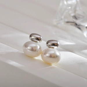 Detailed close-up of vintage silver oval metal studs with warm white pearls on leather