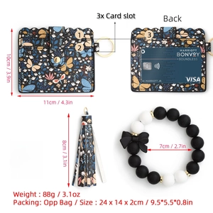 Detailed spec view of butterfly print wallet with beaded wristlet and tassel keychain