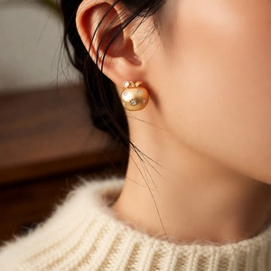 Detailed view of an 18K gold-plated apple earring with shimmering star-set zircons