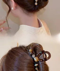 Detail of amber texture hair claw with beads and elegant matching pearl earrings