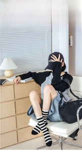 Classic crew-length black and white striped cotton socks styled in a lifestyle setting