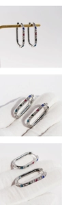 Detail view of U-shaped silver earrings with vibrant multi-colored inlaid zircon stones