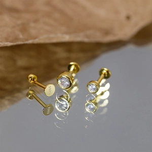 Macro shot of three gold S925 sterling silver stud earrings with hallmarked screw flat backs