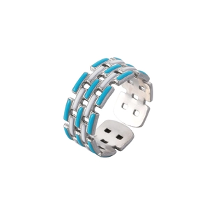 Detail of hollow woven stainless steel ring with blue and white enamel inlay patterns