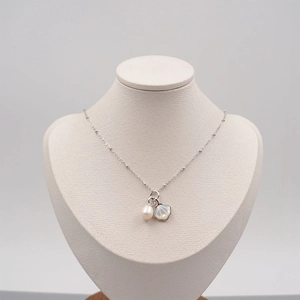 Minimalist silver chain necklace with freshwater pearl and shell pendant on a bust