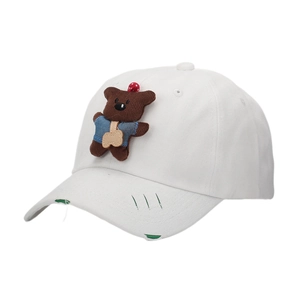 Detail of white cotton baseball cap featuring a corduroy bear patch and distressed holes