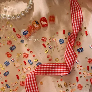 Detail of Chinese New Year nail stickers featuring red and gold lion dance motifs