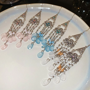 Detail view of bohemian fringe tassel earrings with colorful beads on white ceramic tray