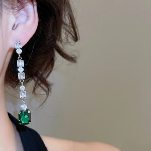 Detail of elegant emerald-cut green crystal earrings with sparkling cubic zirconia fringe