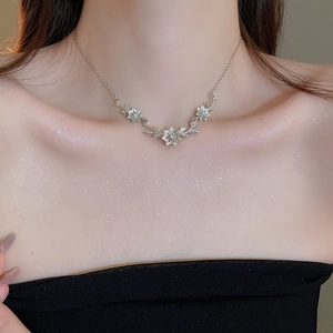 Close-up of silver flower pendant necklace with shimmering crystals on a model neck