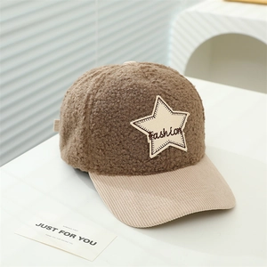 Detail der braunen Kinder-Baseballcap aus Lammfell mit beigem Stern-Patch und Stickerei