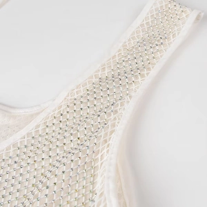Détail de la bretelle en mesh blanc ornée de strass diagonaux et de reflets brillants
