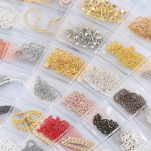 Detailed view of assorted pearl and rhinestone nail art metal chains in a storage box