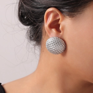 Elegant vintage silver round textured earrings made of stainless steel on model