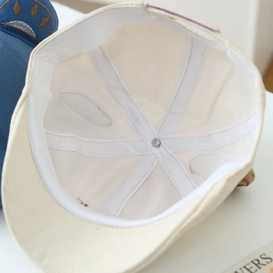 Beige baby beret cap with breathable mesh lining and reinforced internal stitching details