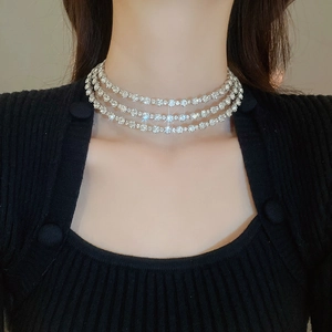 Close-up of triple-layered silver rhinestone choker necklace on a model neckline