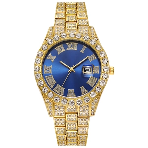 Macro detail of gold iced-out watch with blue Roman dial and crystal-studded bezel