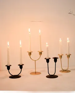 Detail view of modern black and gold metal candle holders with white spiral candles
