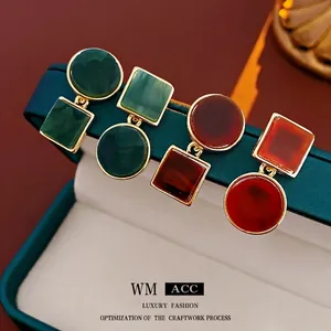Asymmetric geometric silver needle earrings with marble resin insets in gold frames