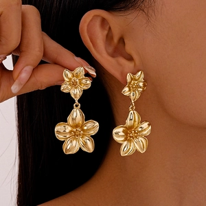 Statement Goldene mehrlagige Blumen Metallohrringe mit poliertem Finish am Modell