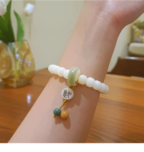 Detail of weather-beaten Bodhi seed bracelet with green jade Ping An Kou and peace charm
