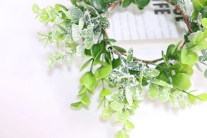 Close-up of green eucalyptus candle ring wreath with white powder finish on leaves