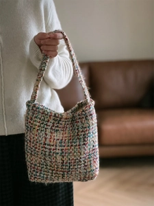 Close-up of colorful tweed knit shoulder bag featuring textured woven woolen material
