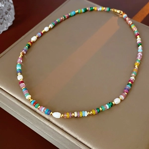 Detail of colorful beads and baroque pearls on an 18K gold plated necklace