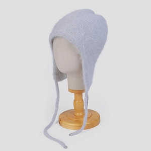 Detailansicht der grauen Strickmütze aus Angora mit Plüschfell und langen Bändern