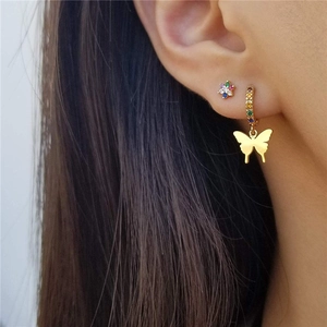 Detail of S925 silver golden butterfly earring and colorful diamond flower stud on ear
