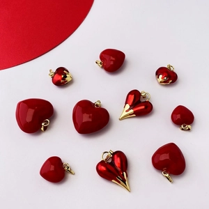 Red heart-shaped charms with gold edges for DIY necklaces on a white background