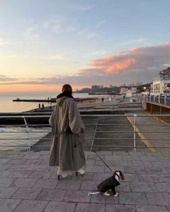 Dettaglio del parka invernale grigio-verde ampio con cappuccio in pelliccia al tramonto