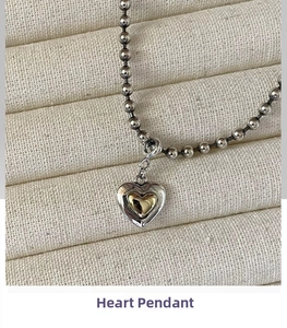 Close-up of vintage heart pendant necklace featuring dual-tone silver and gold layers